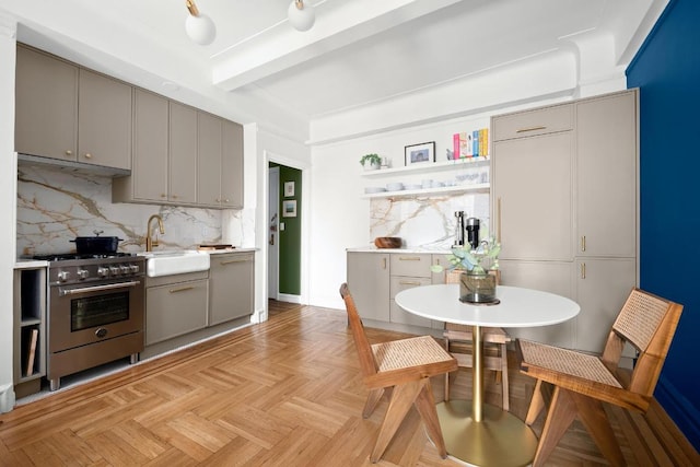 kitchen featuring light parquet flooring, sink, stainless steel stove, and gray cabinetry