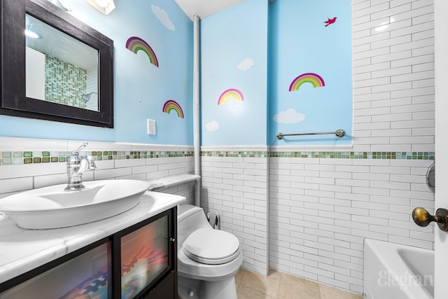 bathroom with wainscoting, toilet, tile patterned floors, vanity, and tile walls