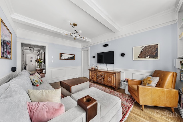 living area with light wood finished floors, crown molding, beam ceiling, and a notable chandelier