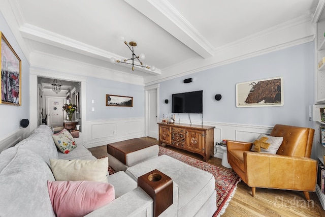 living room featuring beamed ceiling, ornamental molding, a notable chandelier, and light hardwood / wood-style flooring