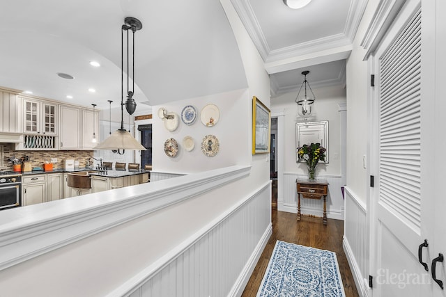 hallway featuring ornamental molding, recessed lighting, a wainscoted wall, and dark wood-type flooring