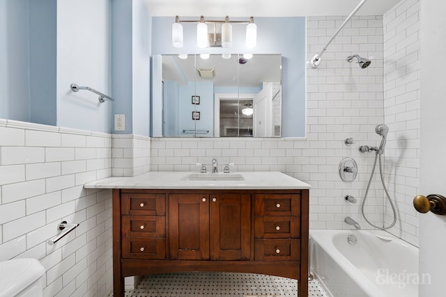 full bathroom featuring toilet, shower / bathing tub combination, tile walls, and vanity