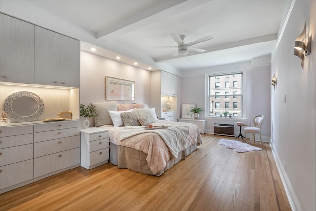 bedroom featuring baseboards, beamed ceiling, a wall mounted air conditioner, and light wood-style floors