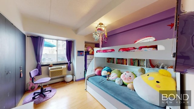 bedroom featuring an AC wall unit and light hardwood / wood-style flooring