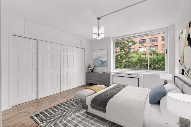 bedroom with an inviting chandelier, a closet, and wood finished floors