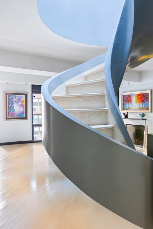 staircase featuring wood-type flooring and a fireplace