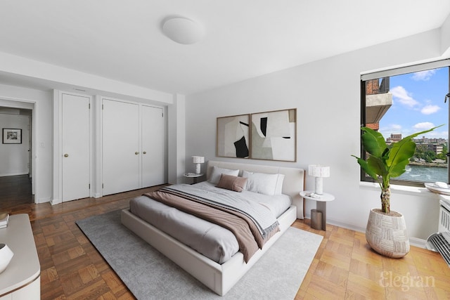 bedroom featuring a water view and parquet floors