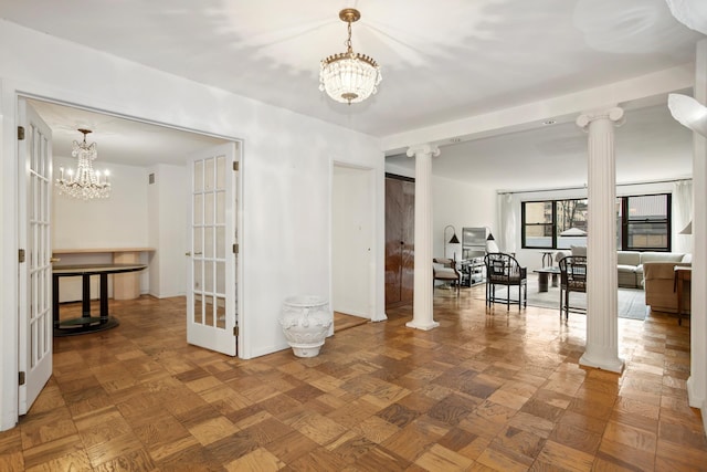 interior space featuring decorative columns and a notable chandelier