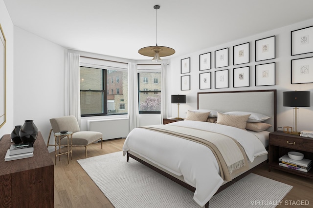 bedroom with radiator and wood finished floors