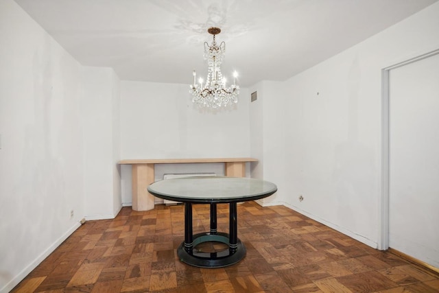 dining room featuring dark parquet floors and a notable chandelier