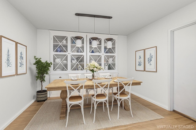 dining space featuring baseboards, wood finished floors, and breakfast area
