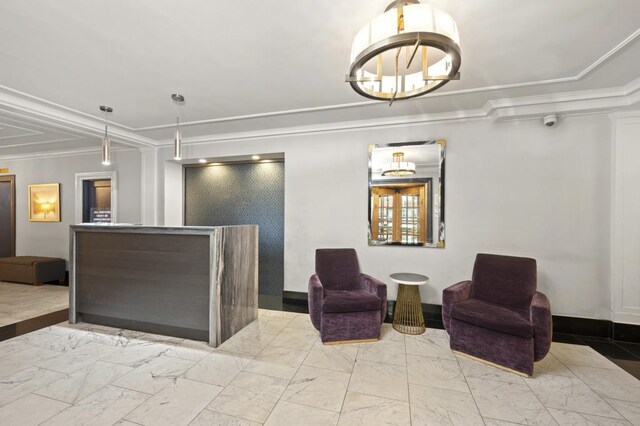 interior space featuring a chandelier, marble finish floor, crown molding, and baseboards