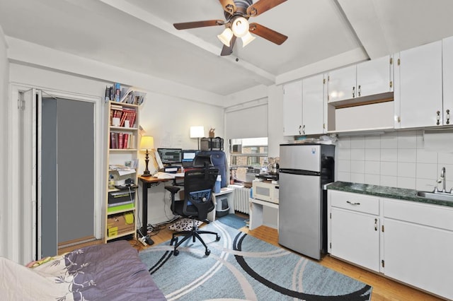 office featuring a ceiling fan, light wood-type flooring, a sink, and radiator heating unit