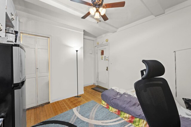 office featuring light wood-style flooring, ceiling fan, and beam ceiling