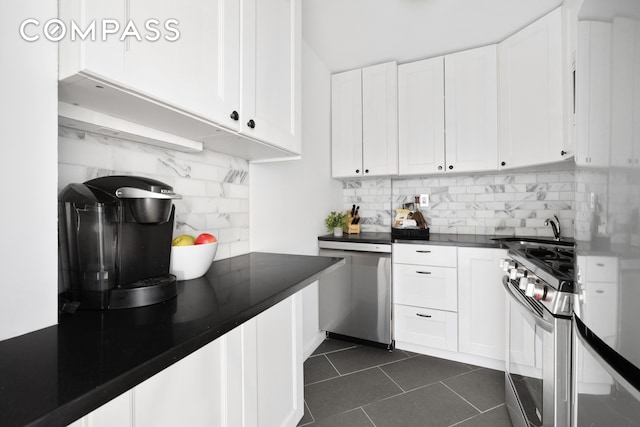 kitchen with dishwasher, gas stove, dark countertops, and backsplash