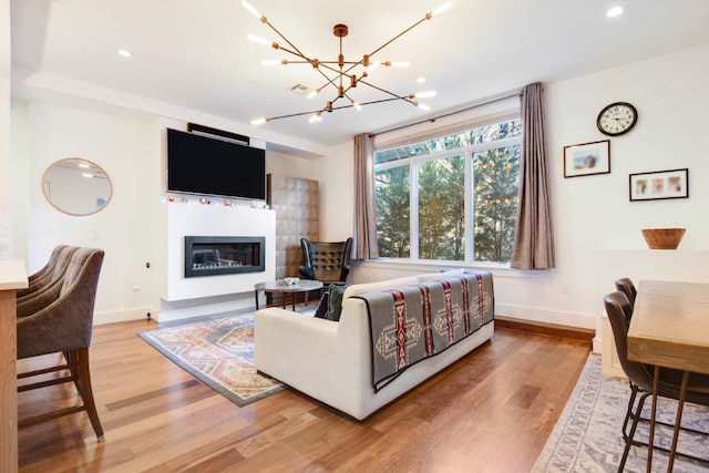 living room with an inviting chandelier and light hardwood / wood-style flooring