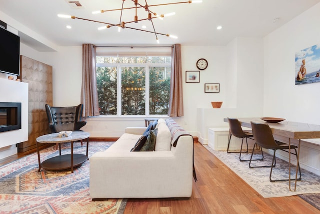 living room featuring an inviting chandelier and light hardwood / wood-style floors