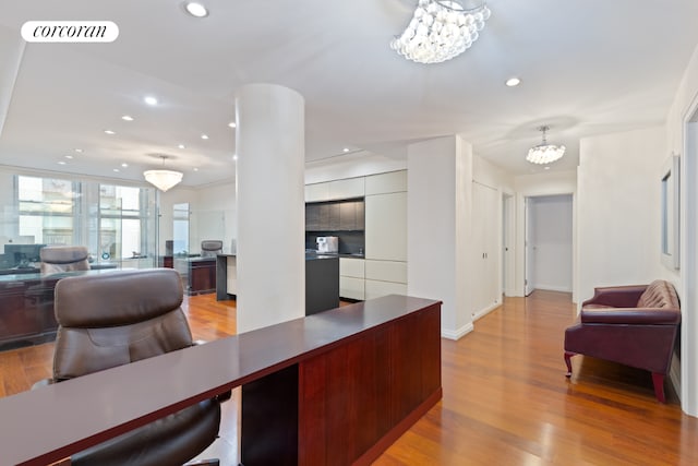 office featuring an inviting chandelier and light hardwood / wood-style flooring