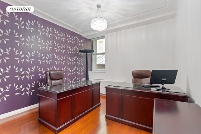 home office with light hardwood / wood-style flooring, ornamental molding, and a notable chandelier