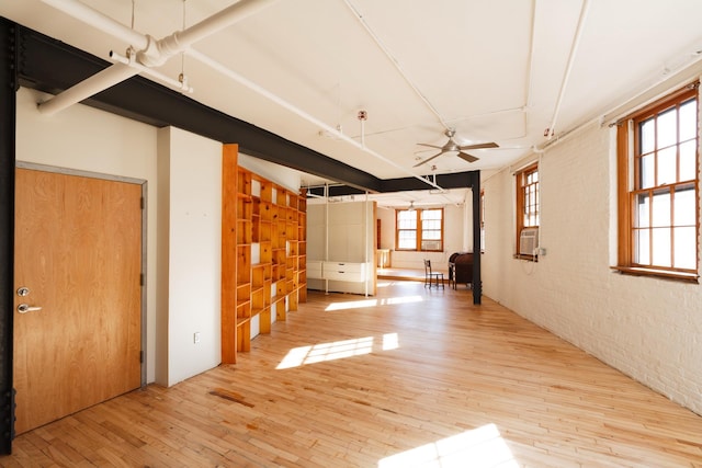 210 Spring St Unit 5Fl, New York City, NY 10013 - unfurnished room featuring ceiling fan, light wood-style floors, cooling unit, and brick wall