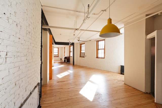210 Spring St Unit 5Fl, New York City, NY 10013 - spare room with light wood finished floors, brick wall, and radiator