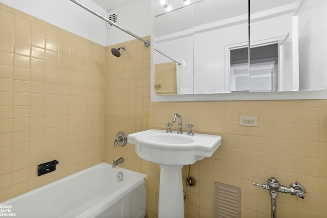 bathroom with tiled shower / bath, tile walls, and decorative backsplash