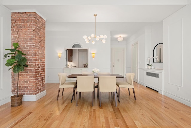 dining area featuring a chandelier, light wood finished floors, baseboards, and radiator