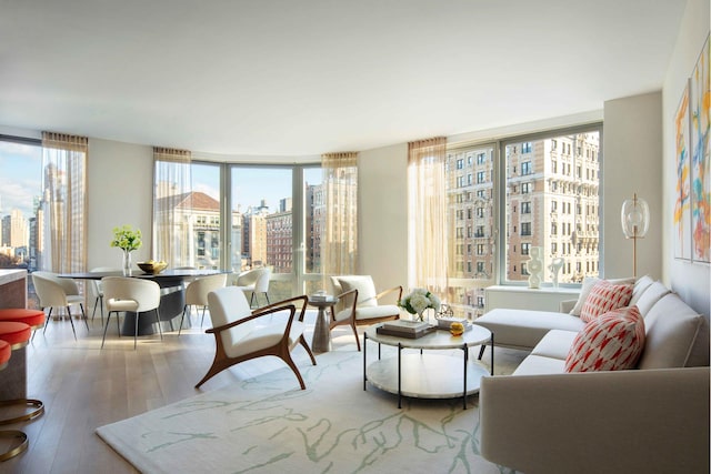 living room featuring wood-type flooring, a view of city, and floor to ceiling windows