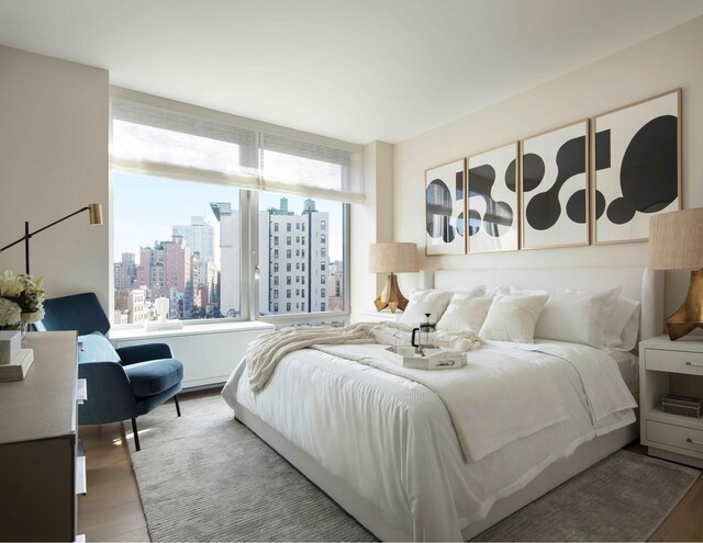 bedroom with wood finished floors and a view of skyline