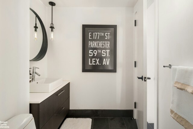 bathroom featuring vanity, tile patterned floors, and toilet