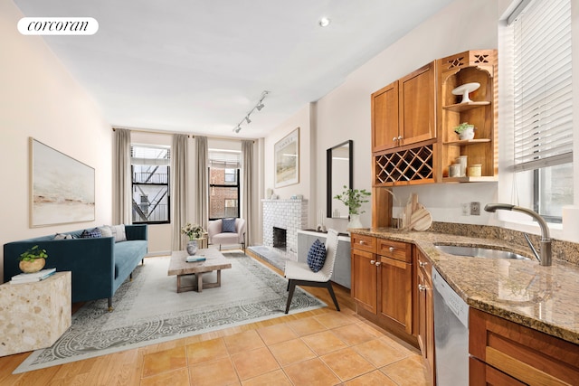 kitchen featuring visible vents, brown cabinetry, dishwasher, open shelves, and a sink