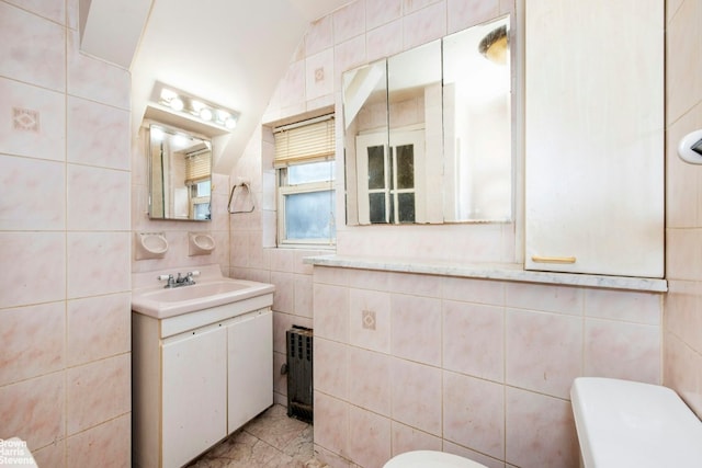 half bath featuring marble finish floor, tile walls, toilet, and vanity