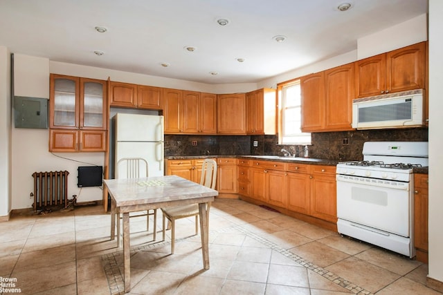 kitchen with white appliances, dark countertops, glass insert cabinets, and radiator