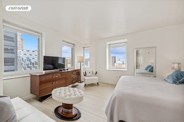 bedroom featuring light wood-type flooring, visible vents, and baseboards