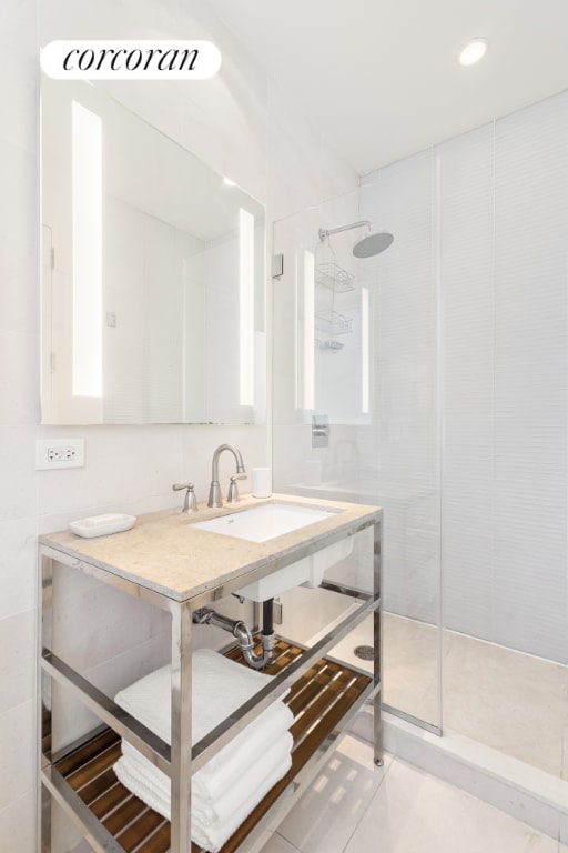 bathroom with tile patterned floors, a sink, recessed lighting, and walk in shower