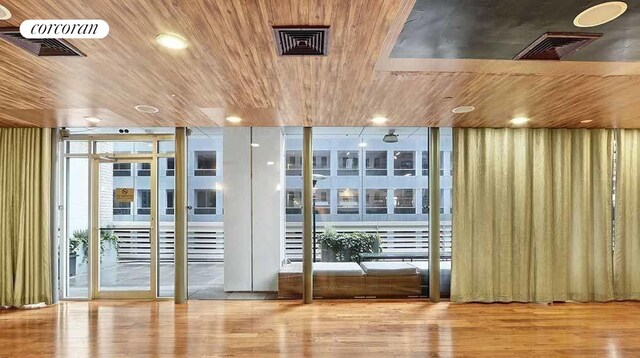 doorway to outside with wood ceiling, wood finished floors, visible vents, and recessed lighting