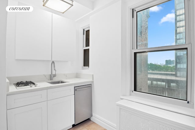 kitchen featuring sink, dishwasher, white cabinetry, radiator heating unit, and light stone counters