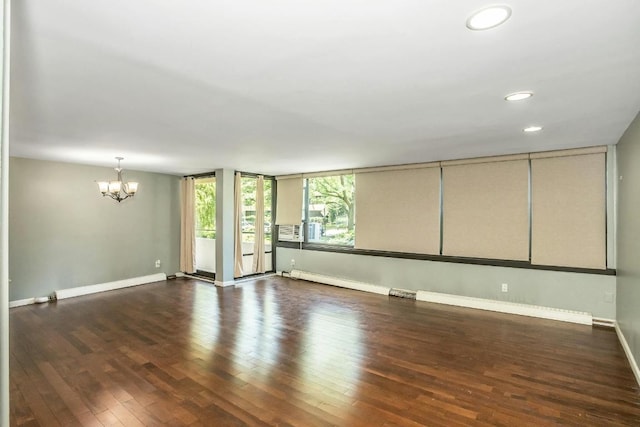 empty room with dark hardwood / wood-style flooring and an inviting chandelier