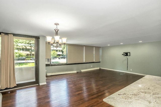 empty room featuring dark hardwood / wood-style flooring and an inviting chandelier