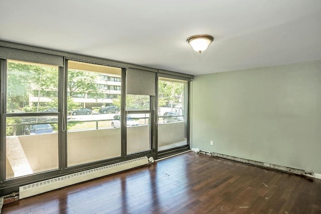 unfurnished room with floor to ceiling windows, dark hardwood / wood-style floors, and a baseboard radiator