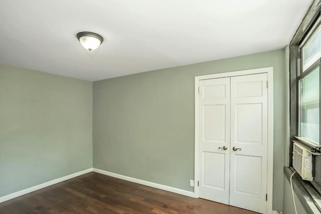 unfurnished bedroom featuring dark hardwood / wood-style floors and a closet