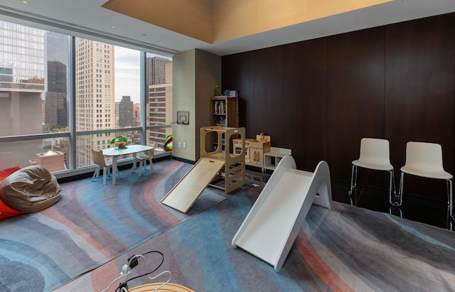 interior space with floor to ceiling windows, a city view, and carpet flooring