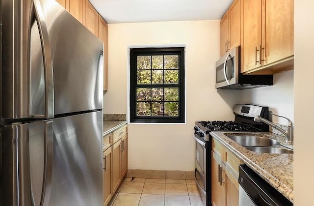 kitchen featuring stainless steel appliances, light tile patterned flooring, light stone countertops, and sink