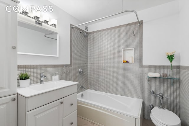 bathroom featuring  shower combination, vanity, and tile walls