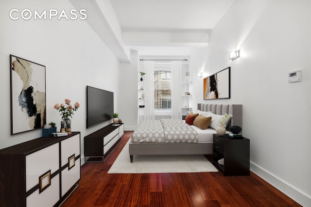 bedroom with baseboards and dark wood-style flooring