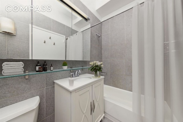 full bathroom with shower / bath combo with shower curtain, tile walls, toilet, and vanity