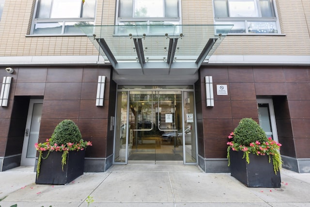 view of exterior entry featuring brick siding