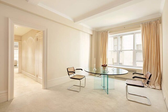 living area featuring light colored carpet and beam ceiling