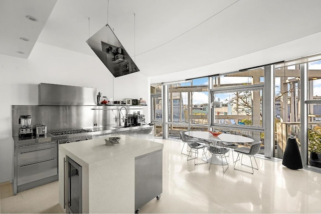 kitchen featuring beverage cooler, a center island, and stainless steel gas cooktop