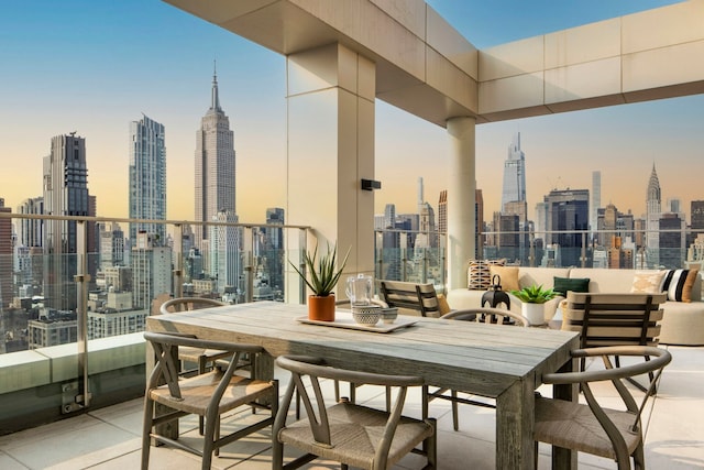 view of patio / terrace with a balcony, a city view, and outdoor dining space